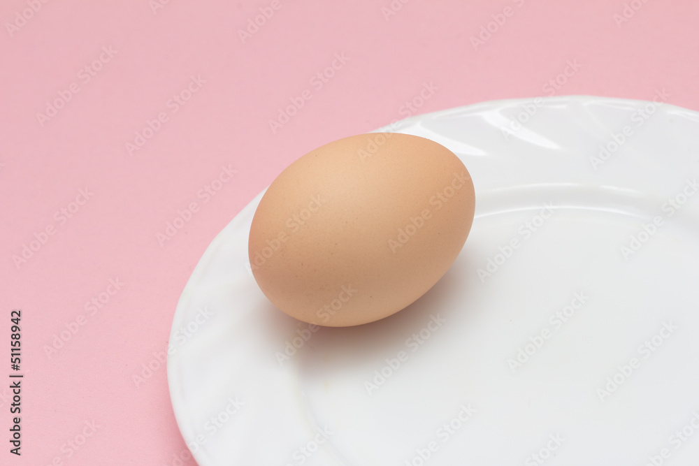 fresh eggs on a plate on pink background