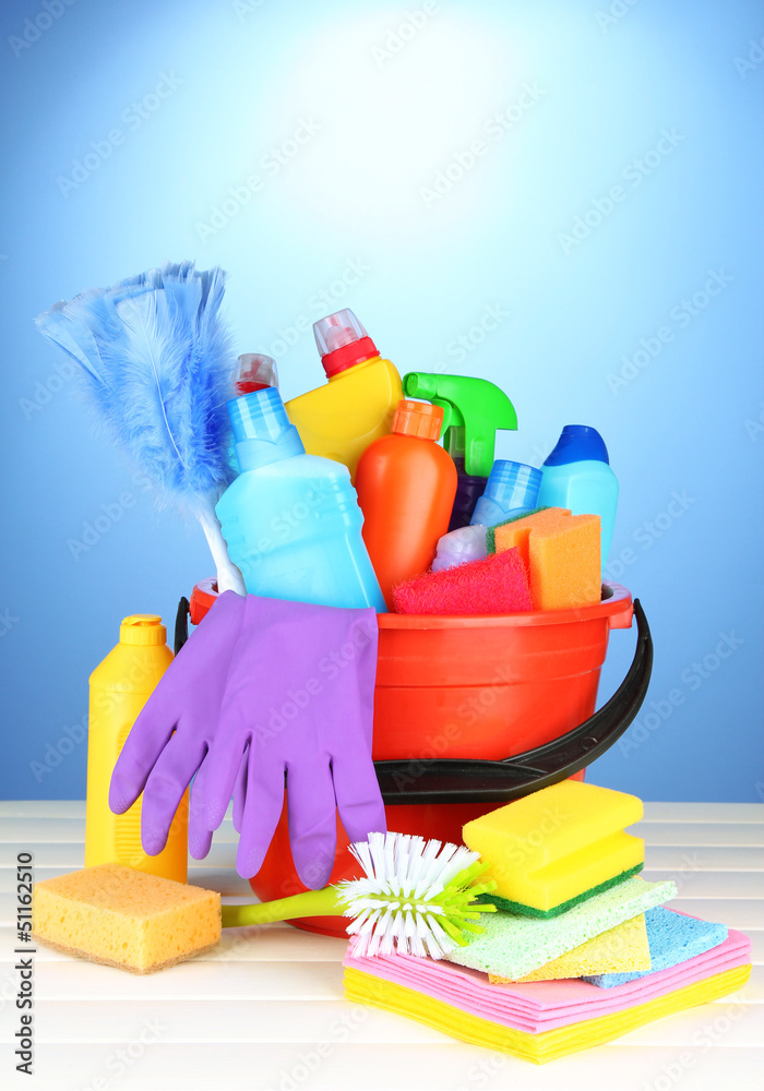 Cleaning items in bucket on color background Cleaning items in bucket on color background