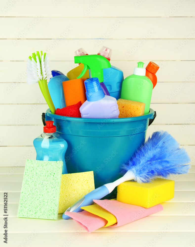 Cleaning items in bucket on white wooden background Cleaning items in bucket on white wooden background