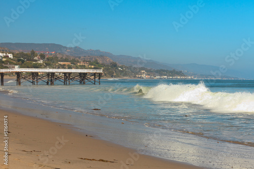 Fototapeta Naklejka Na Ścianę i Meble -  White wooden pier on the beach of Malibu. USA. California.