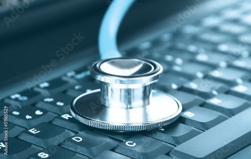 Computer concept of a stethoscope closeup on a computer keyboard