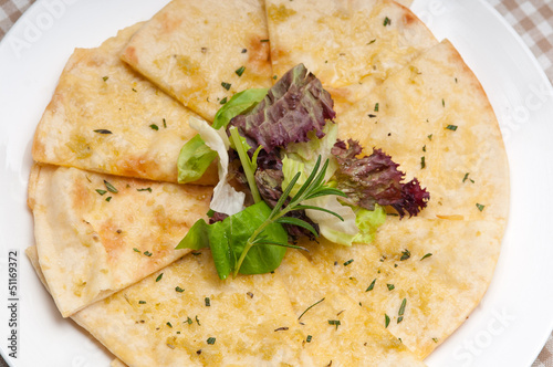 garlic pita bread pizza with salad on top