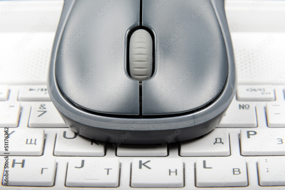A wireless mouse placed on laptop keyboard A wireless mouse placed on laptop keyboard