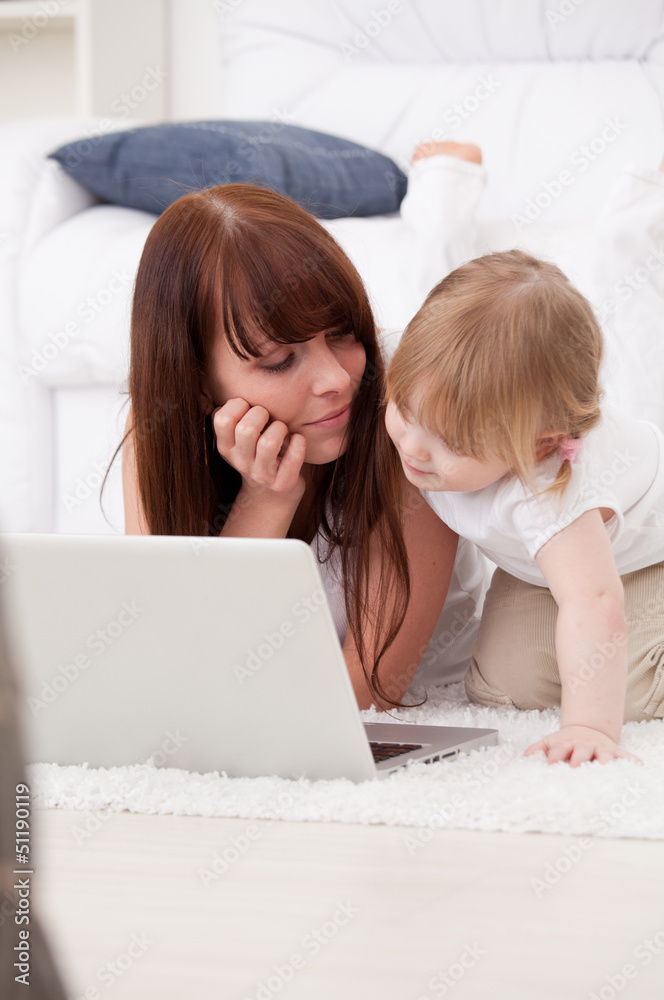 Happy young mother and her daughter using a laptop Happy young mother and her daughter using a laptop