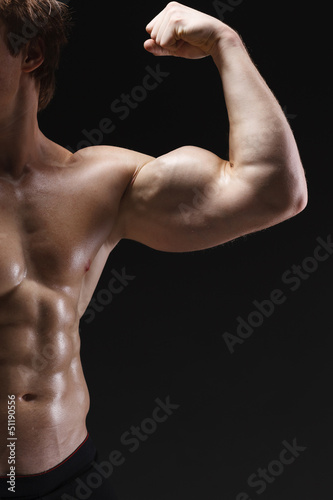 Cropped picture of muscle man posing in studio