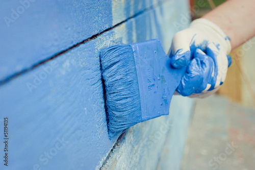 hand painting blue wooden wall 