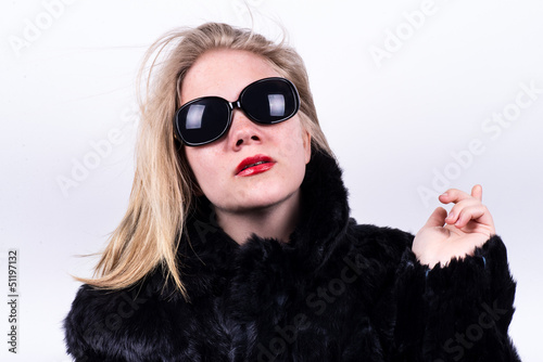 upper class girl in dark sunglasses, red lipstick and fur