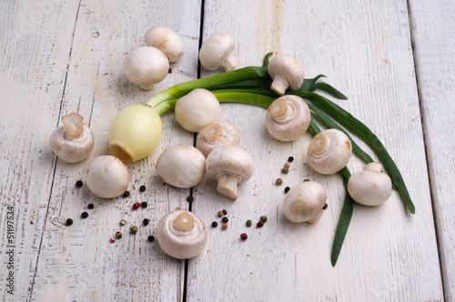 Fresh mushrooms and onion on a wooden board
