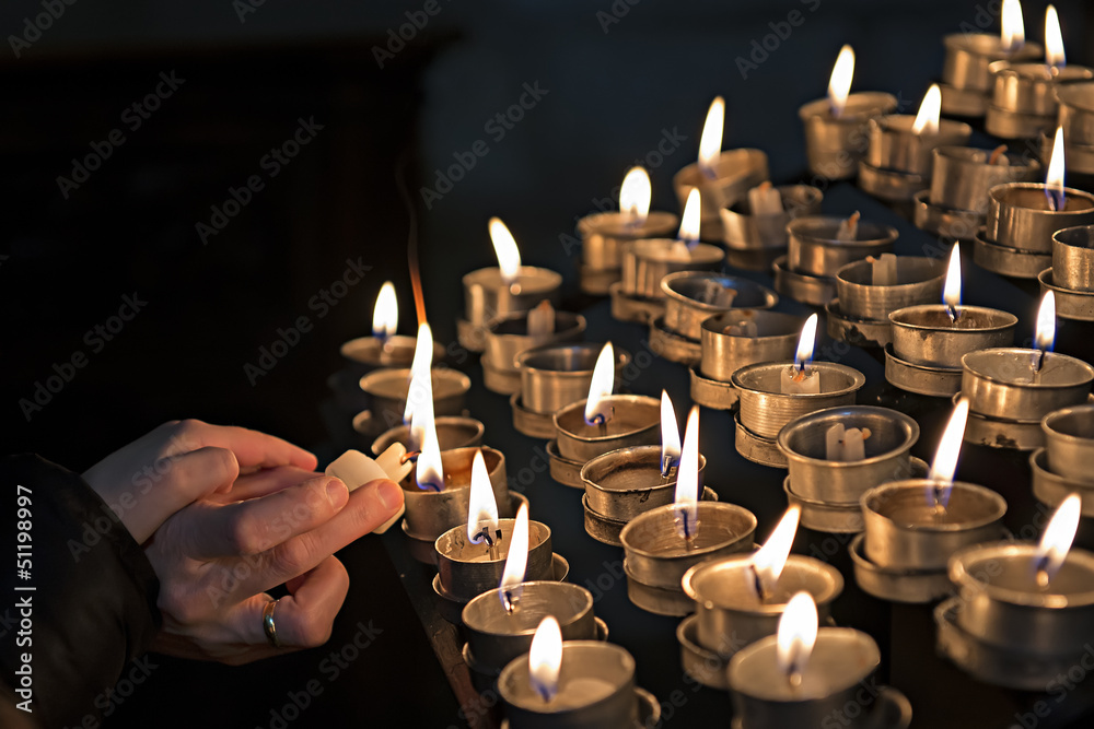 Encendiendo velas en una iglesia a modo de ofrenda. foto de Stock | Adobe  Stock