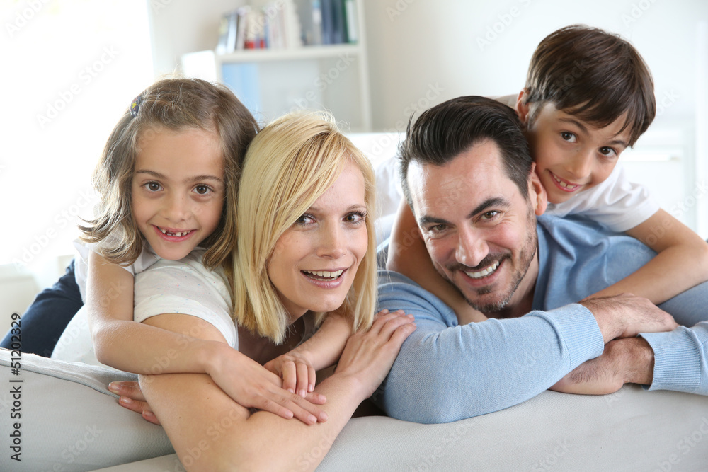 Family of four sitting in sofa at home Family of four sitting in sofa at home