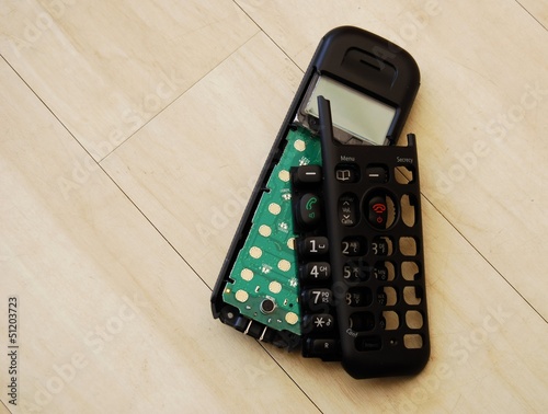 Broken phone handset on wooden floor