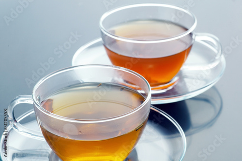 Transparent cup with green and black tea
