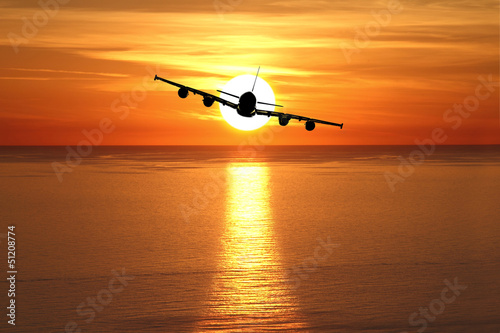 Beautiful sunset with airplane over the sea © viperagp