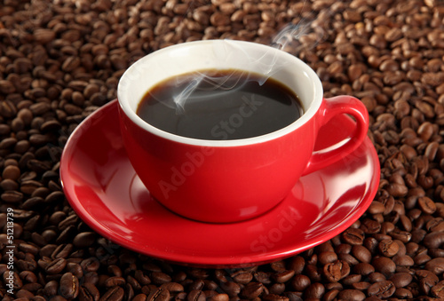 Cup of coffee on coffee beans background
