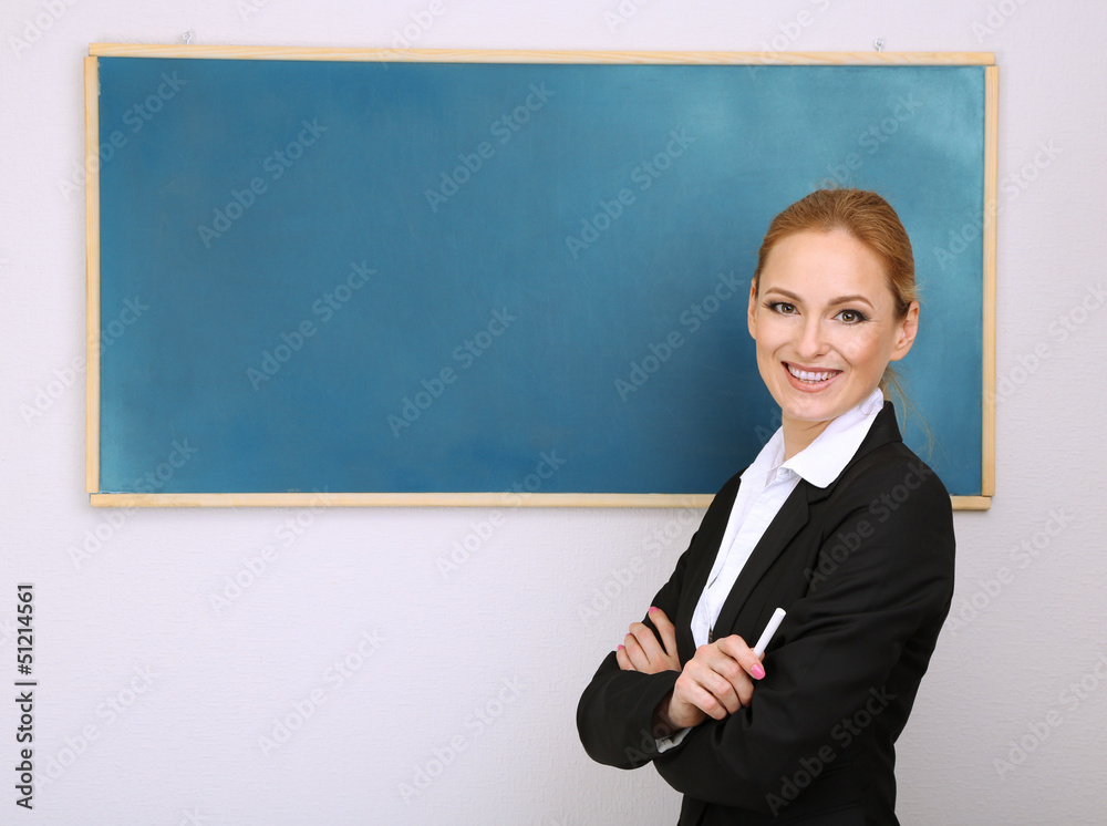 Portrait of teacher woman near chalkboard in classroom Portrait of teacher woman near chalkboard in classroom
