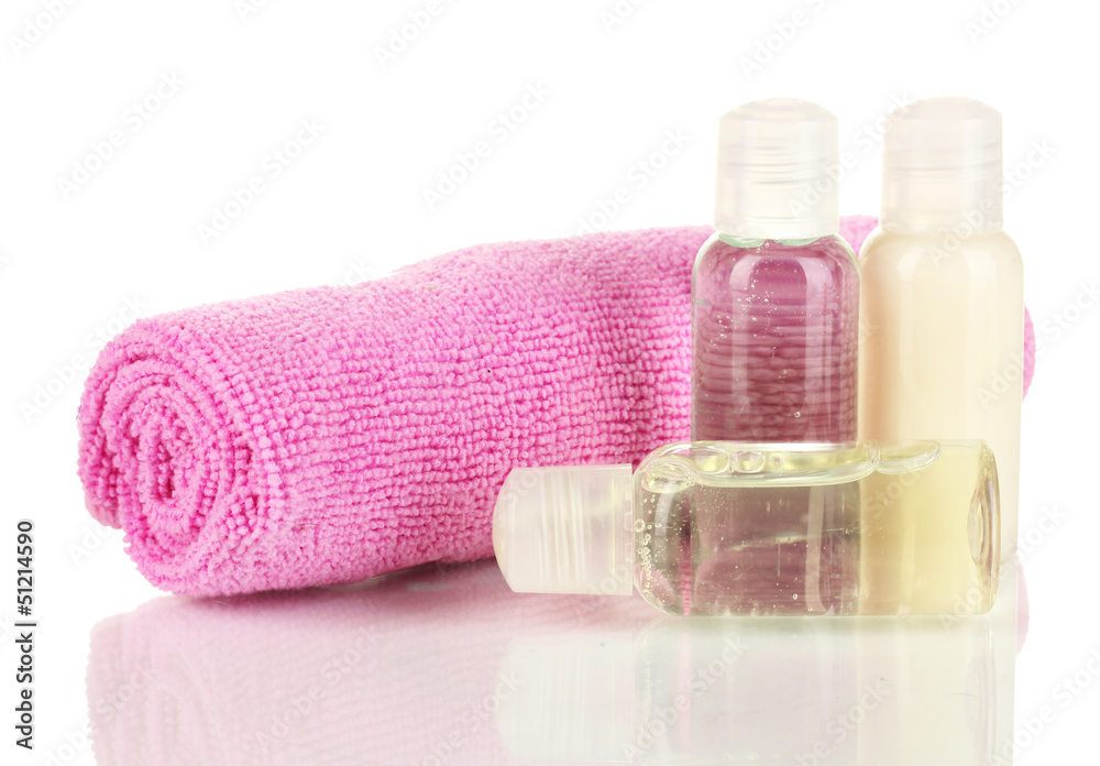 Hotel cosmetic bottles with towel isolated on white