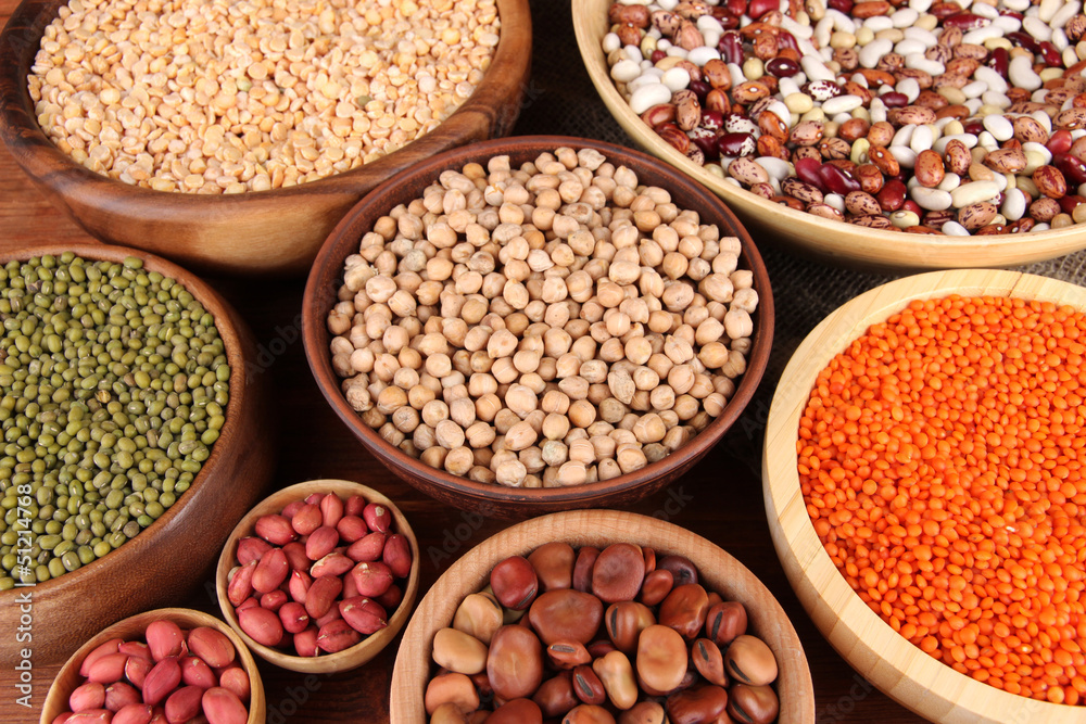 Different kinds of beans in bowls on wooden background Different kinds of beans in bowls on wooden background