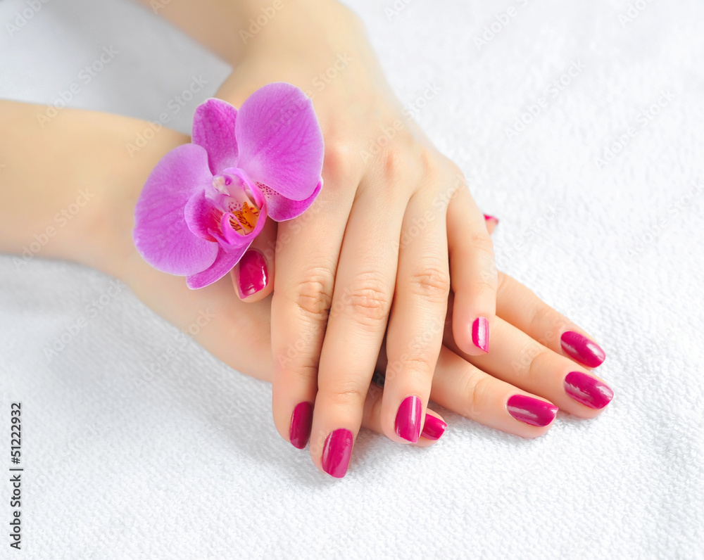 Beautiful hands with manicure and purple orchid flower Beautiful hands with manicure and purple orchid flower