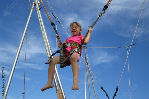 Girl bungee jumping on a trampoline