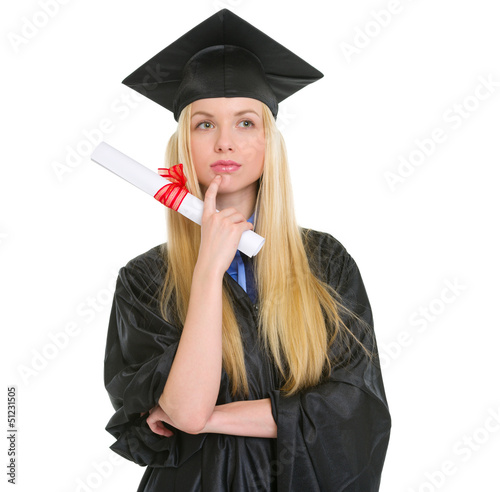 Thoughtful young woman in graduation gown with diploma