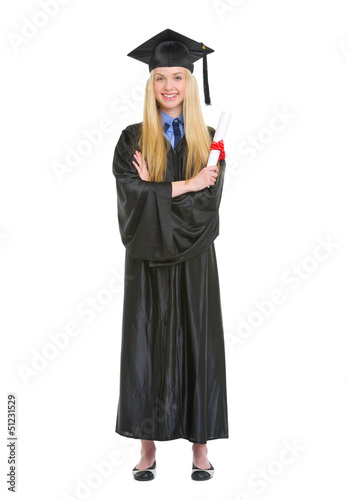Smiling young woman in graduation gown holding diploma