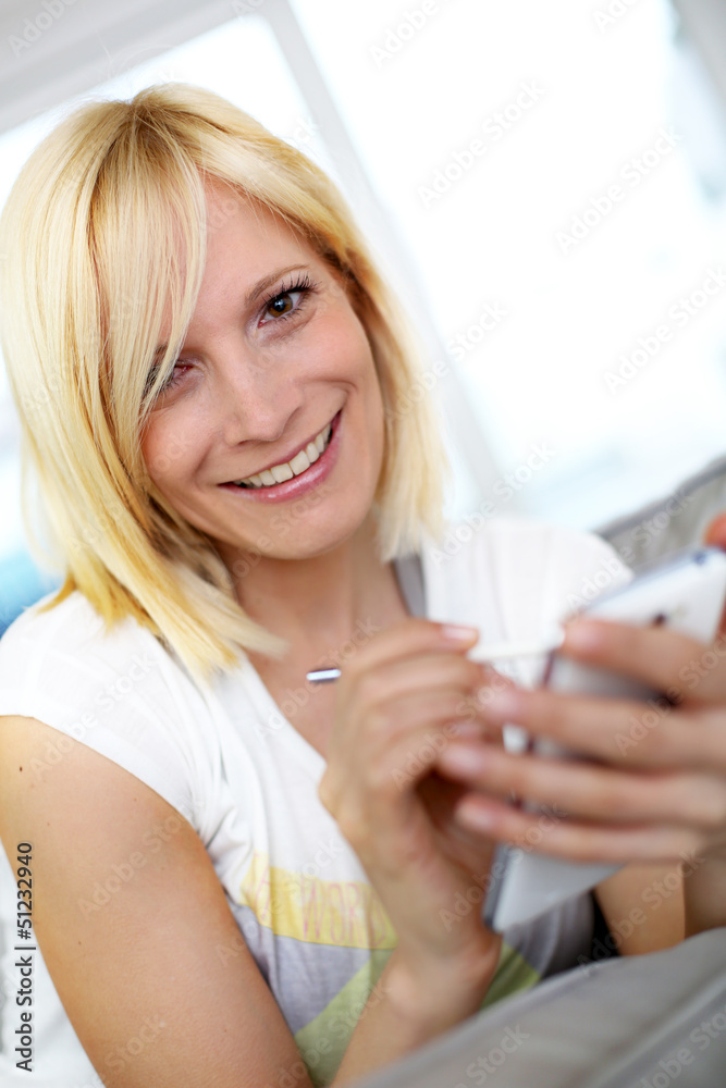 Smiling young woman at home using smartphone Smiling young woman at home using smartphone