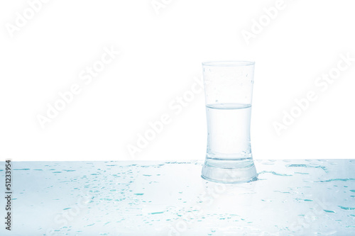 Glass of water with drops on white background