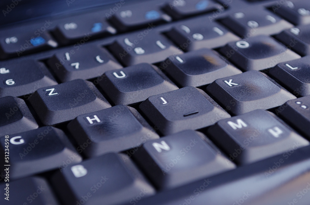 Black keyboard illuminated by screen low angle Black keyboard illuminated by screen low angle