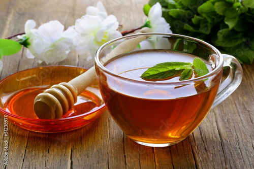 cup of tea with mint and honey on a wooden table photo