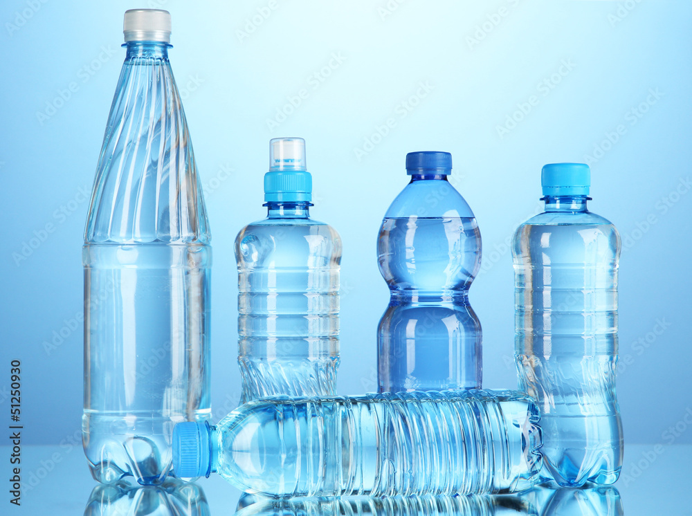 Naklejka premium Different water bottles on blue background