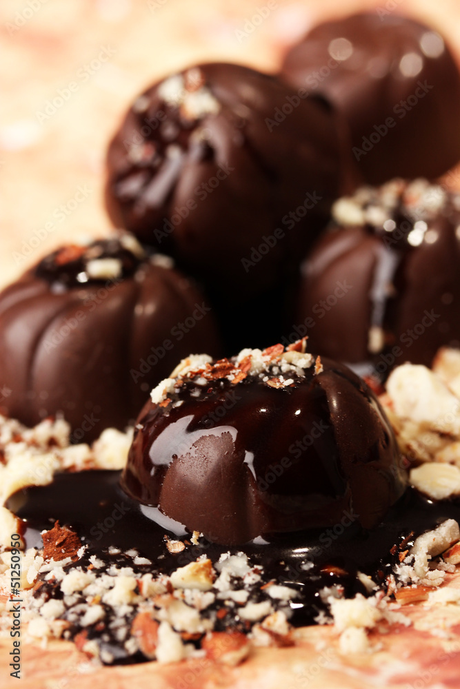 Chocolate candies with nuts, on color background Chocolate candies with nuts, on color background