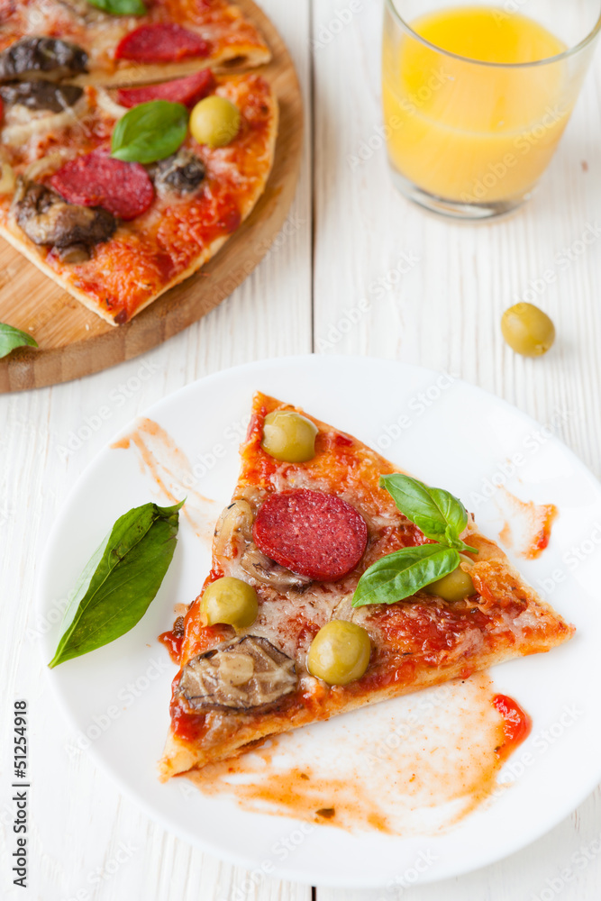 slice of pizza on a plate and pizza on background slice of pizza on a plate and pizza on background
