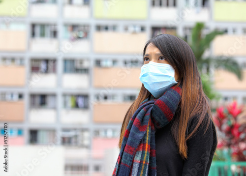 Woman wearing medical face mask in crowded city © leungchopan