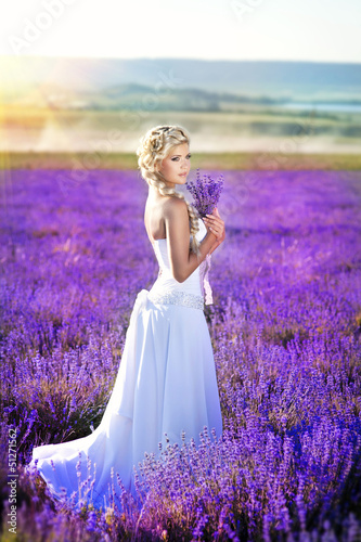 Beautiful bride in lavender field at wedding dress