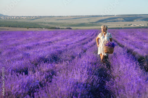 Beautiful blonde woman with lavendar in blossom field