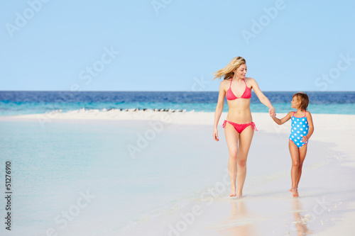 Mother And Daughter Walking On Beautiful Beach