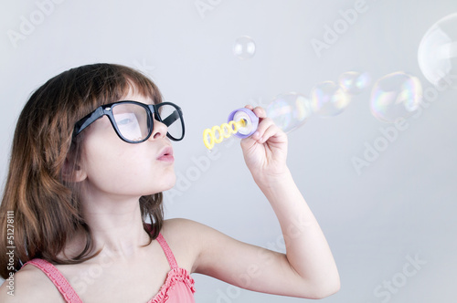 child blowing soap bubbles