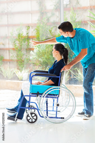 caring husband and disabled wife looking outside window