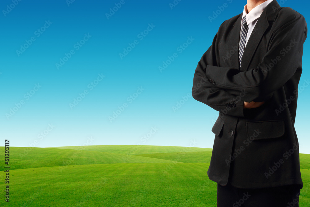 Businessman standing near grass field Businessman standing near grass field