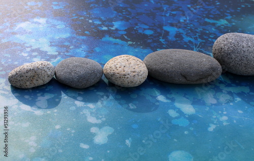 Zen rocks in line on bright blue background