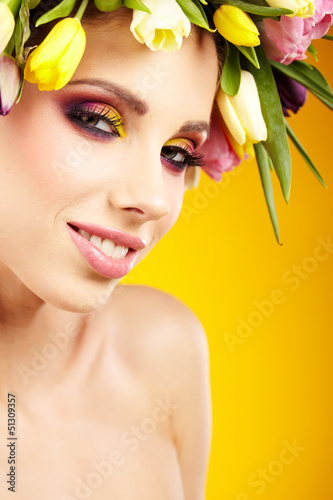 woman portrait with wreath from flowers on head over spring bac