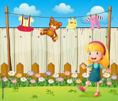 A backyard with hanging clothes and a young girl