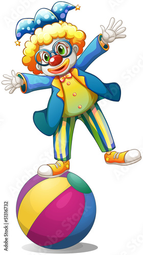 A playful male clown at the top of a ball