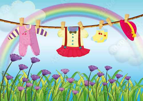 Hanging baby clothes near the garden with fresh flowers