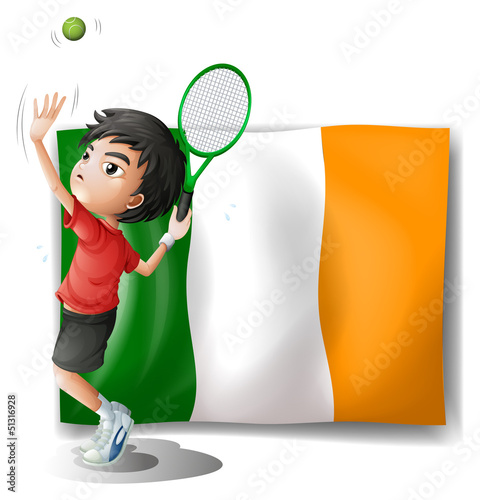 A boy playing tennis in front of the Ireland flag