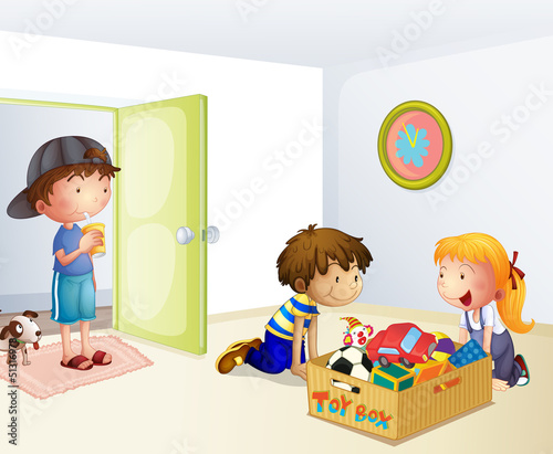 Three kids inside the house with a box of toys