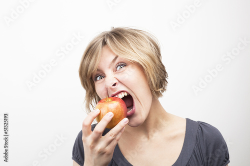 young woman eating apple on white background