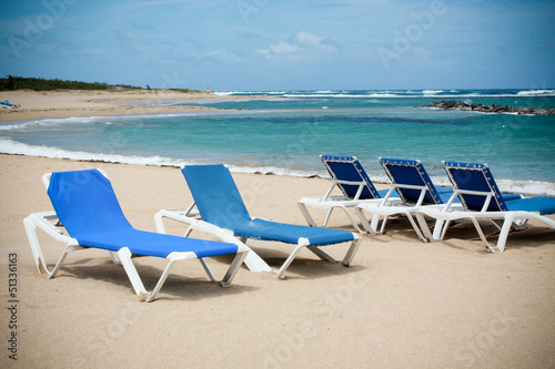 calm beach with deckchairs under the blue sky