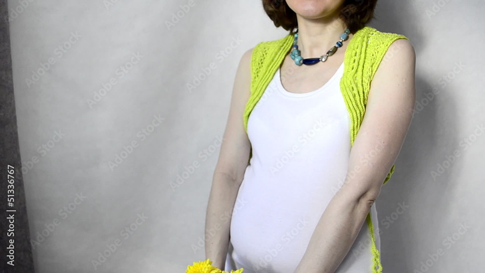 Pregnant woman smelling yellow flowers