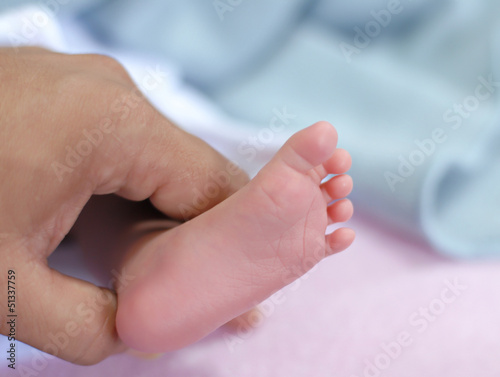 new born baby feet in hand